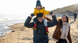 Family walking on beach in winter